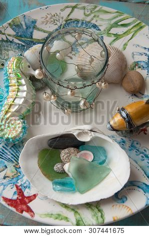 This Is A Beach Theme Still Life Of Sea Glass, A Cermanic Sea Horse Ornament, Small Glass Jar With W