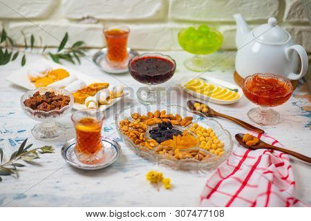 Tea Set With Varieties Of Traditional Nuts, Lemon, Confiture And Sweets Served On White Tablecloth -