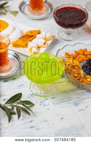 Tea Set With Varieties Of Traditional Nuts, Lemon, Confiture And Sweets Served On White Tablecloth -
