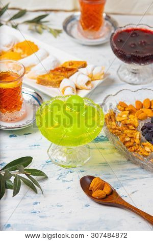 Tea Set With Varieties Of Traditional Nuts, Lemon, Confiture And Sweets Served On White Tablecloth -