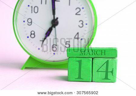 March 14th. Day 14 Of Month, Handmade Wood Calendar And Alarm Clock On Light Green Color. Spring Mon