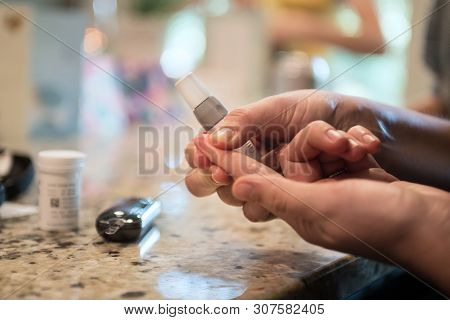 Woman Using Diabetes Healthcare Blood Sugar Glucose Measurement System At Home