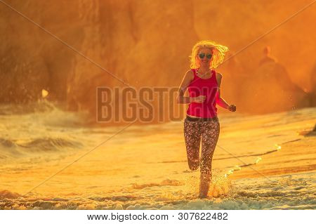 Sport, Outdoor Life And Healthy Lifestyle Concept. Happy Blonde Woman Running On Seashore Of El Mata