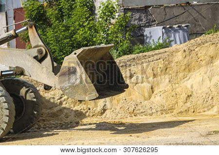 Tractor Collects Scoop With  Gravel. Excavator Extracts Sand And Gravel For  Concrete Mix.