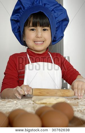 Bambina cucinare una pizza in una cucina.Ragazzino in una cucina.Bambina cucinare una pizza in un ki