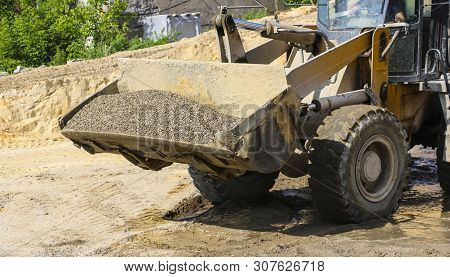 Tractor Collects Scoop With  Gravel. Excavator Extracts Sand And Gravel For  Concrete Mix.