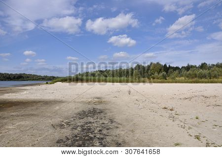 Wide Blue River Is Slow Flowing. Summer. Sunny Weather And White Sand. Green Trees Far Away
