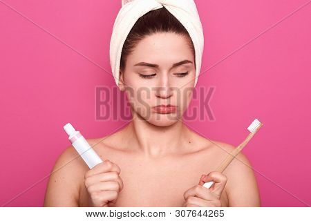 Close Up Portrait Of Upset Woman With Pouting Lips, Brushing Her Teeth Isolated Over Pink Background