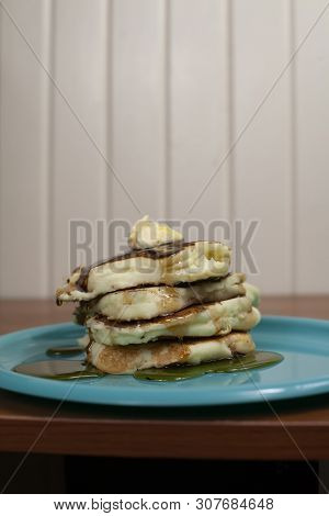 Stack Of Pancakes Topped With Butter And Slathered In Syrup