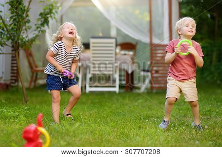 Cute Little Boy And Girl Playing In Game Throwing Rings At Summer Outdoors. Games For Family With Ki