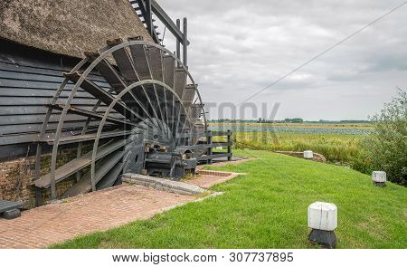 Close-up Of The Paddlewheel Of A Historic Dutch Polder Windmill. The Restored Thatched Wooden Hollow