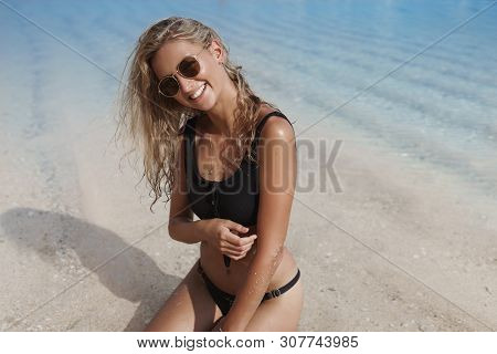 Charming Blond Girlfried Perfect Tan Sit Black Bikini Ocean Sandy Beach Tilting Head Sensually Smili