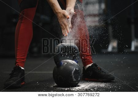 Closeup Of Female Athlete Claping Hands With Cloud Of Dust While Magnesia Protection. Sports Woman G