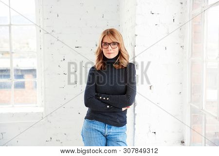 Beautiful Smiling Woman Standing With Arms Crossed While Relaxing At The Window