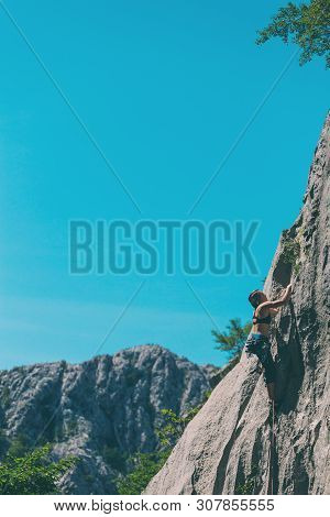 Rock Climbing And Mountaineering In The Paklenica National Park. A Woman Overcomes A Challenging Cli