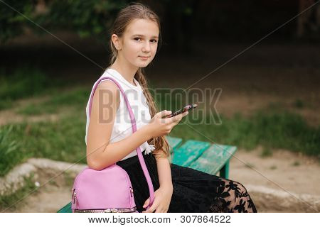 Young Girl Use Phone During School Break. Girl Play Online Games