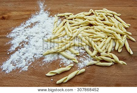 Uncooked Fusilli Al Ferretto, On Flour On Wooden Table