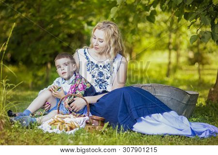 Portrait Of Happy Caucasian Mother And Her Little Kid.posing With Basket Full Of Bread Rings Outdoor