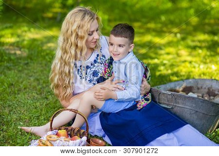 Happy Caucasian Mother With Her Little Kid. Posing With Basket Full Of Bread Rings Outdoors.horizont