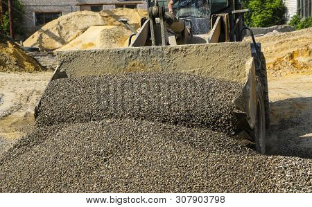 Tractor Collects Scoop With  Gravel. Excavator Extracts Sand And Gravel For  Concrete Mix.