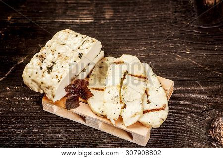 Halumi Cheese On A Wooden Background. Preparation Of Cheese Halumi. Cheese Halumi With Mint