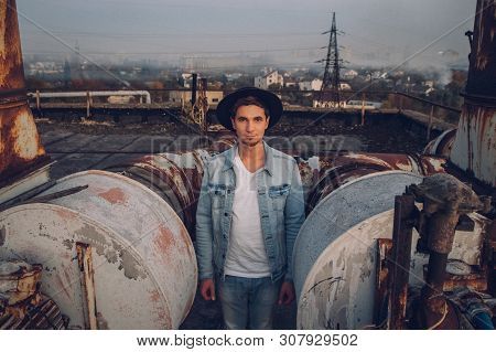 Urban Man With Hat Against The Background Of The City. Cool Guy. Wearing White Shirt And Jeans. Old 