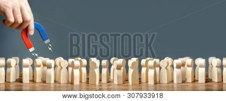 Hand With A Magnet Is Combing Through A Crowd. Search For Suitable People For Work, Patients For Don