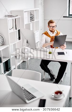 Mid Age Businessman Working With Dokuments At The Computer In Office