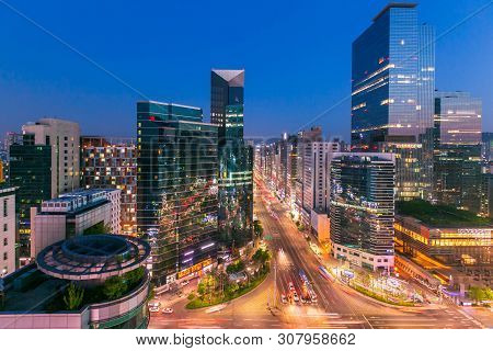 Seoul City Skyling And Skyscraper And Traffic At Niaht Intersection In Gangnam, South Korea.