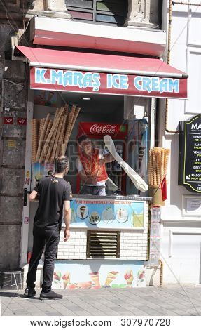 ISTANBUL, TURKEY - JUNE 7, 2019: Turkish ice cream vendor demonstrates the sticky chewy turkish ice cream dondurma