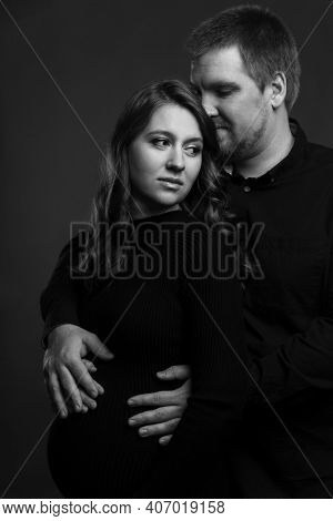 Young Couple Embrace Tenderly And Sensually. Black And White Photo. Vertical. Pregnant Woman With He