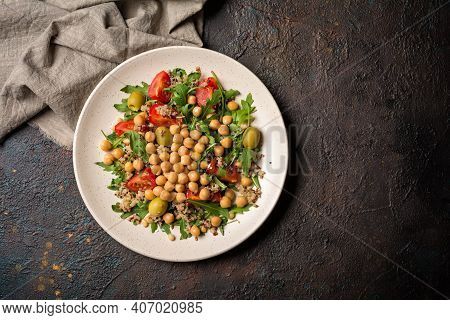 Healthy Vegetarian Salad With Cooked Chickpeas, Chia Seeds, Fresh Arugula, Cherry Tomatoes And Olive
