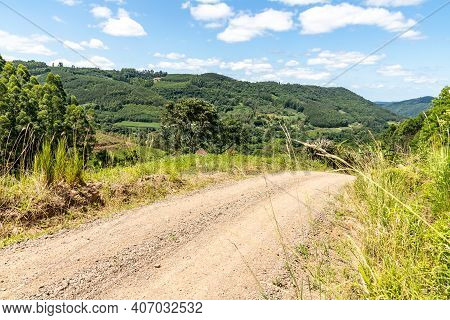 Dirty Road And Farms With Forest Around