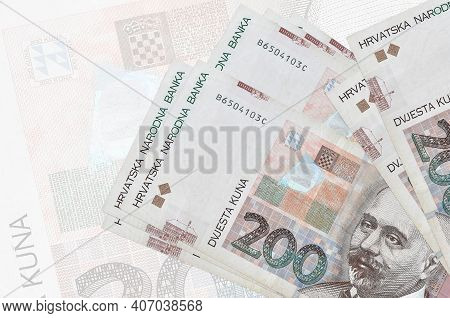200 Croatian Kuna Bills Lies In Stack On Background Of Big Semi-transparent Banknote. Abstract Prese