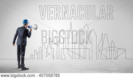 Businessman in hard hat holding blueprint with VERNACULAR inscription, engineering and architecture concept