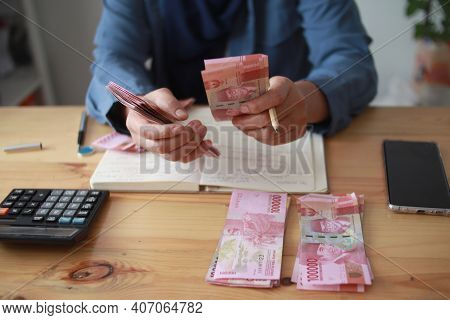 Close Up Of Woman Hand Counting Money Uang Indonesian Rupiah And Making Notes, Money Financial Manag