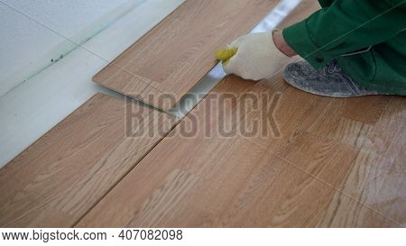 May Laying Laminate Flooring At Home. Installing Laminated Floor, Detail On Wooden Tiles Ready To Be