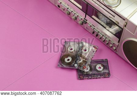 Boombox Stereo Radio Cassette Recorder And Random Cassettes On Pink Background. Vintage Cassette Dec