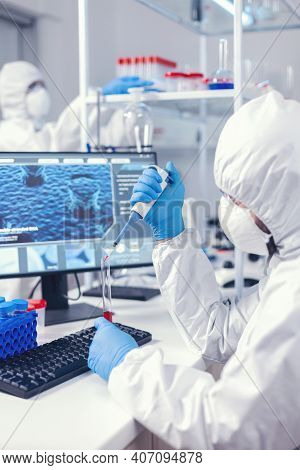 Scientist Taking Blood Sample From Test Tube Using Micropipette. Doctor Working With Various Bacteri
