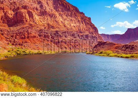 Historic boat crossing Lee's Ferry. Smooth turn of the magnificent Colorado River. USA. Amazing wildlife. Steep river banks of red sandstone. The concept of active, extreme and photo tourism