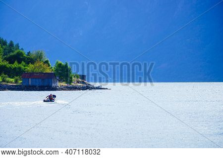 Solvorn Village On Fjord Shore In Luster Municipality, Vestland County, Norway. Person Ride In Motor