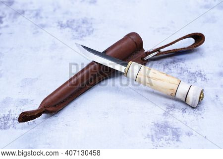Hunting Knife With Short Blade And Bone Handle With Leather Case On Gray Concrete Background. Items 