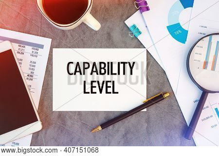 Capability Level Is Written In A Document On The Office Desk With Office Accessories, Coffee, Diagra