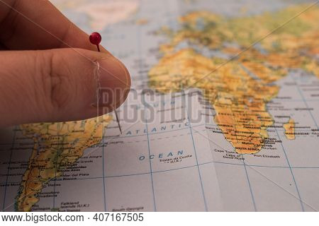 Close Up On A Hand Placing A Pin On A World Map