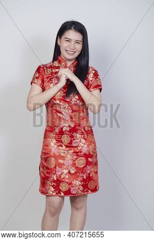 Happy Chinese New Year. Beautiful Asian Woman Wearing Traditional Cheongsam Qipao Dress With Gesture