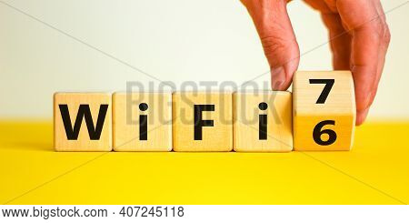 Wifi 6 Or 7 Symbol. Businessman Turns A Wooden Cube And Changes The Words Wifi 6 To Wifi 7. Beautifu