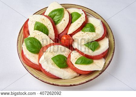 Tomatoes With Mozzarella And Basil Laid Out On A Plate