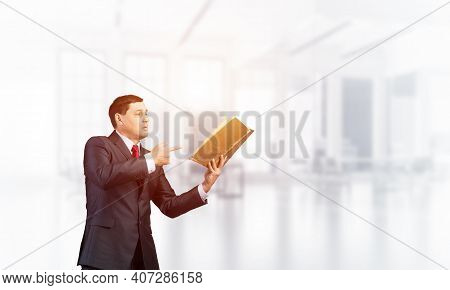 Senior Businessman Finger Pointing Into Open Book. Portrait Of Adult Man In Business Suit And Tie St