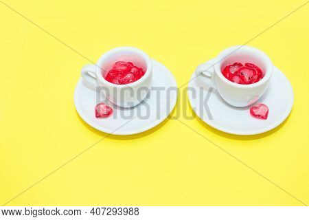 Two Cups With Hearts On A Red Background. The View From The Top. Red Hearts Spilled Out. Isolated On