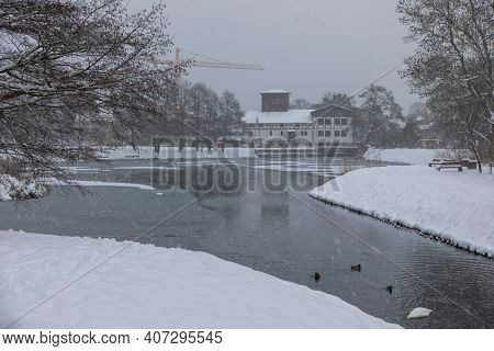 Snowstorm At The Mill Pond In Oliwa. Old Mill In The Background. Gdansk, Oliwa, Poland.